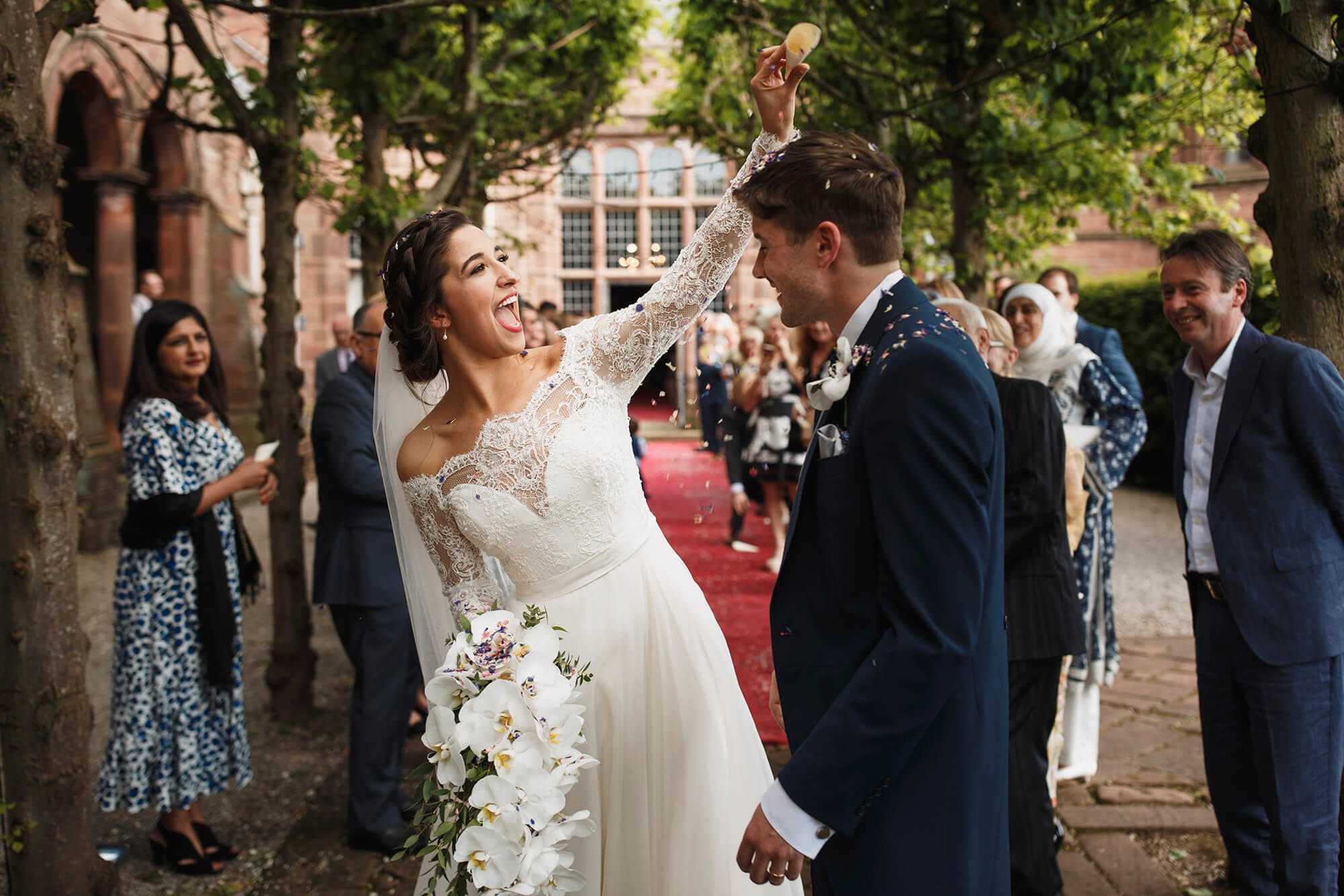 Bride throwing confetti on groom Thornton Manor House
