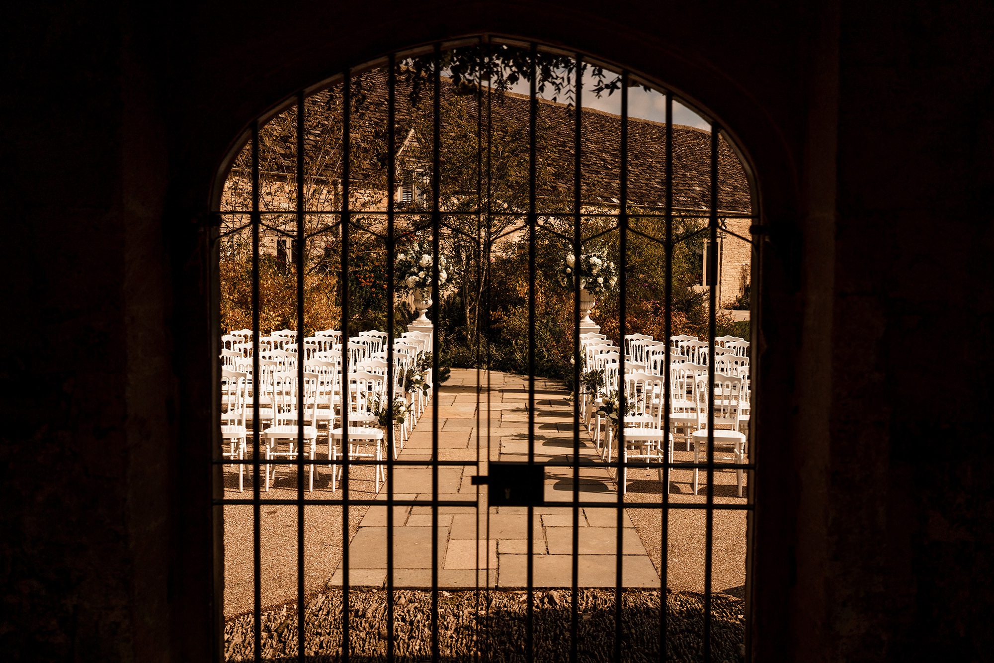 view through iron gates of chairs at Caswell House 