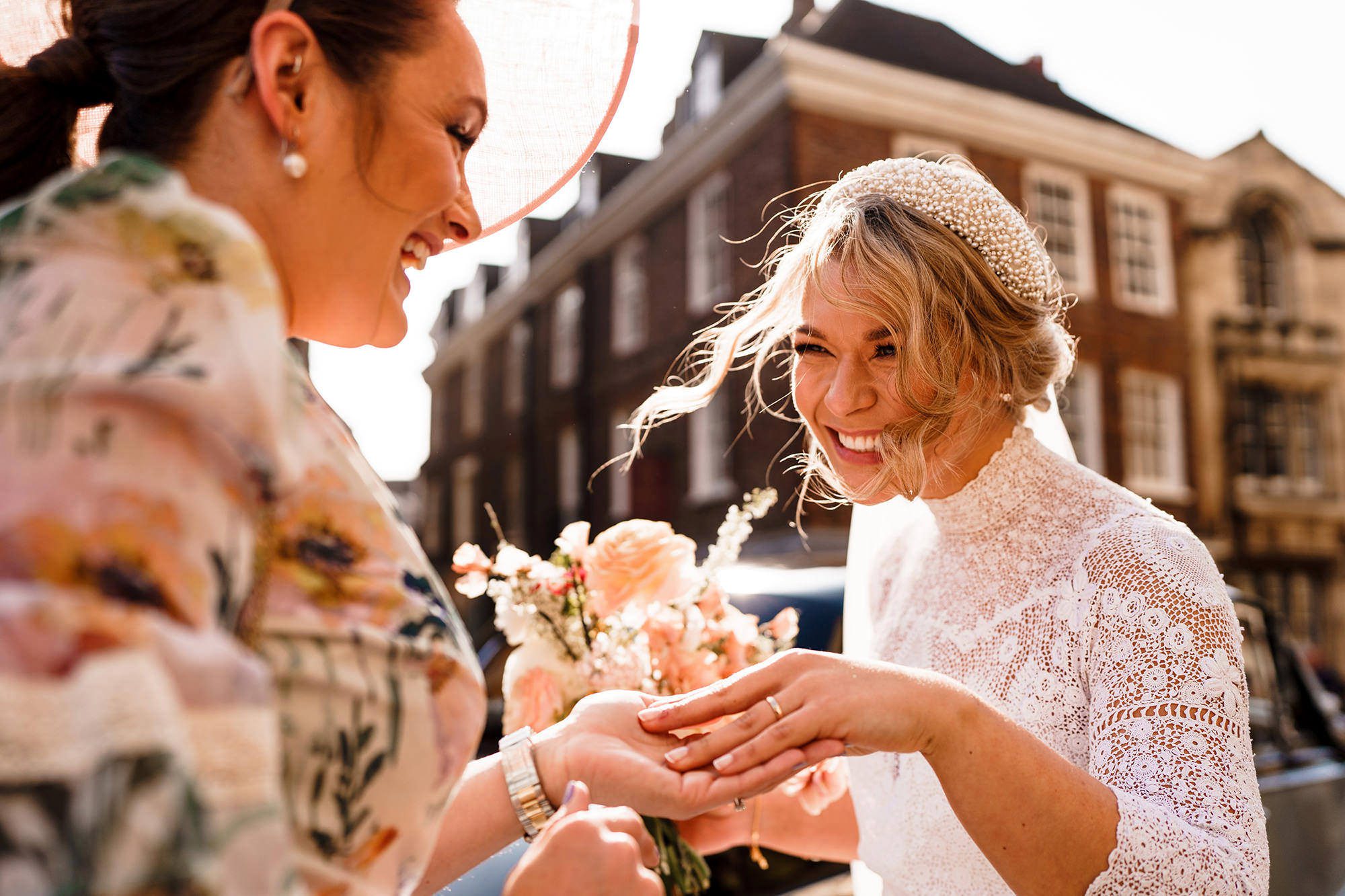 bride shows off her wedding ring to a guest 
