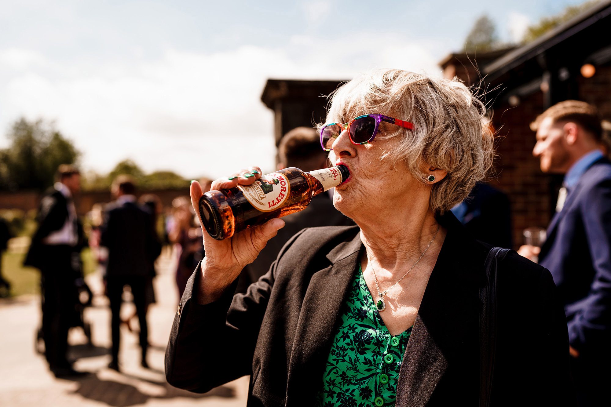 wedding guest drinks a beer in the Lake District sunshine