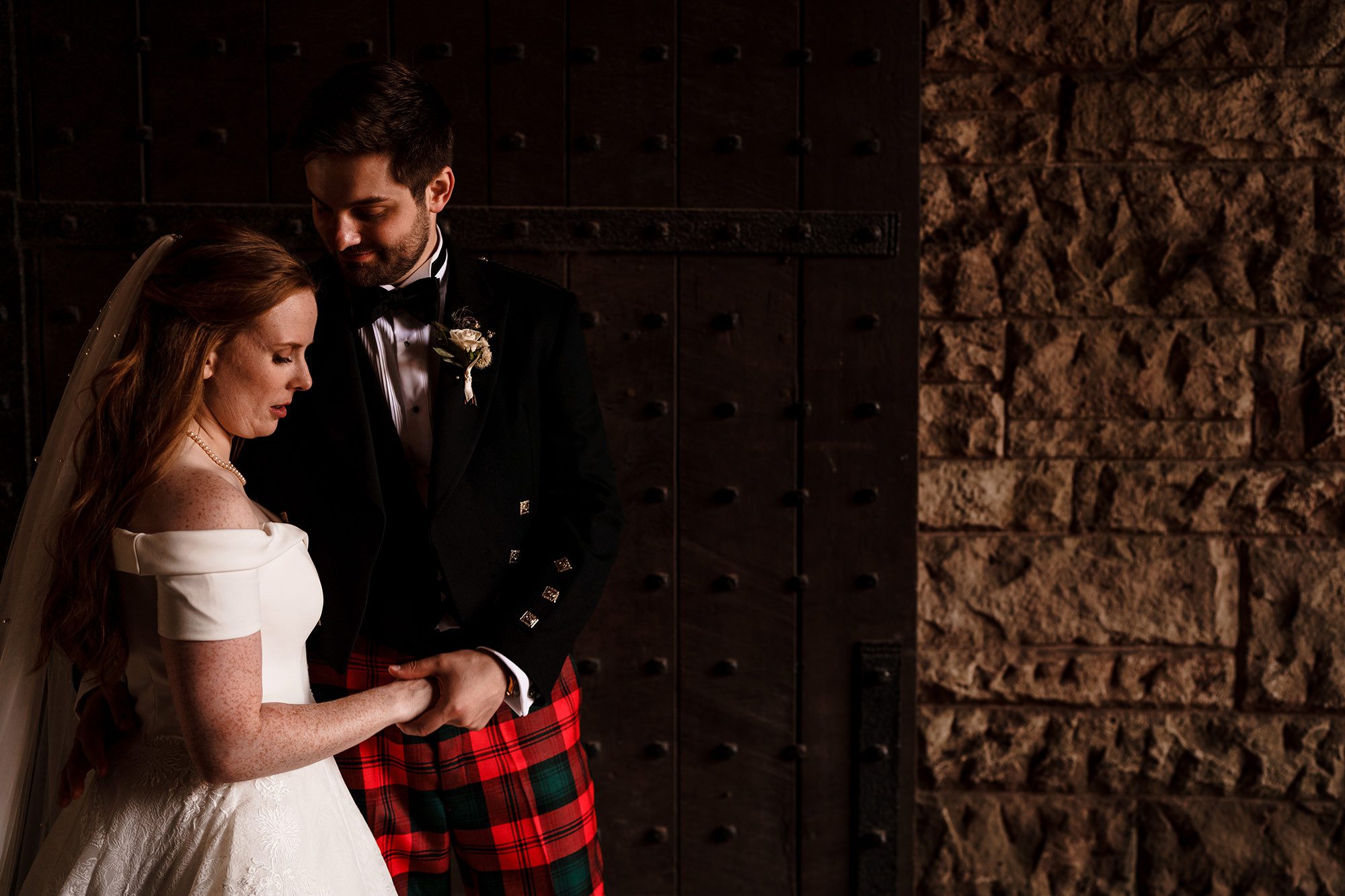 bride and groom at the gates of peckfoton castle