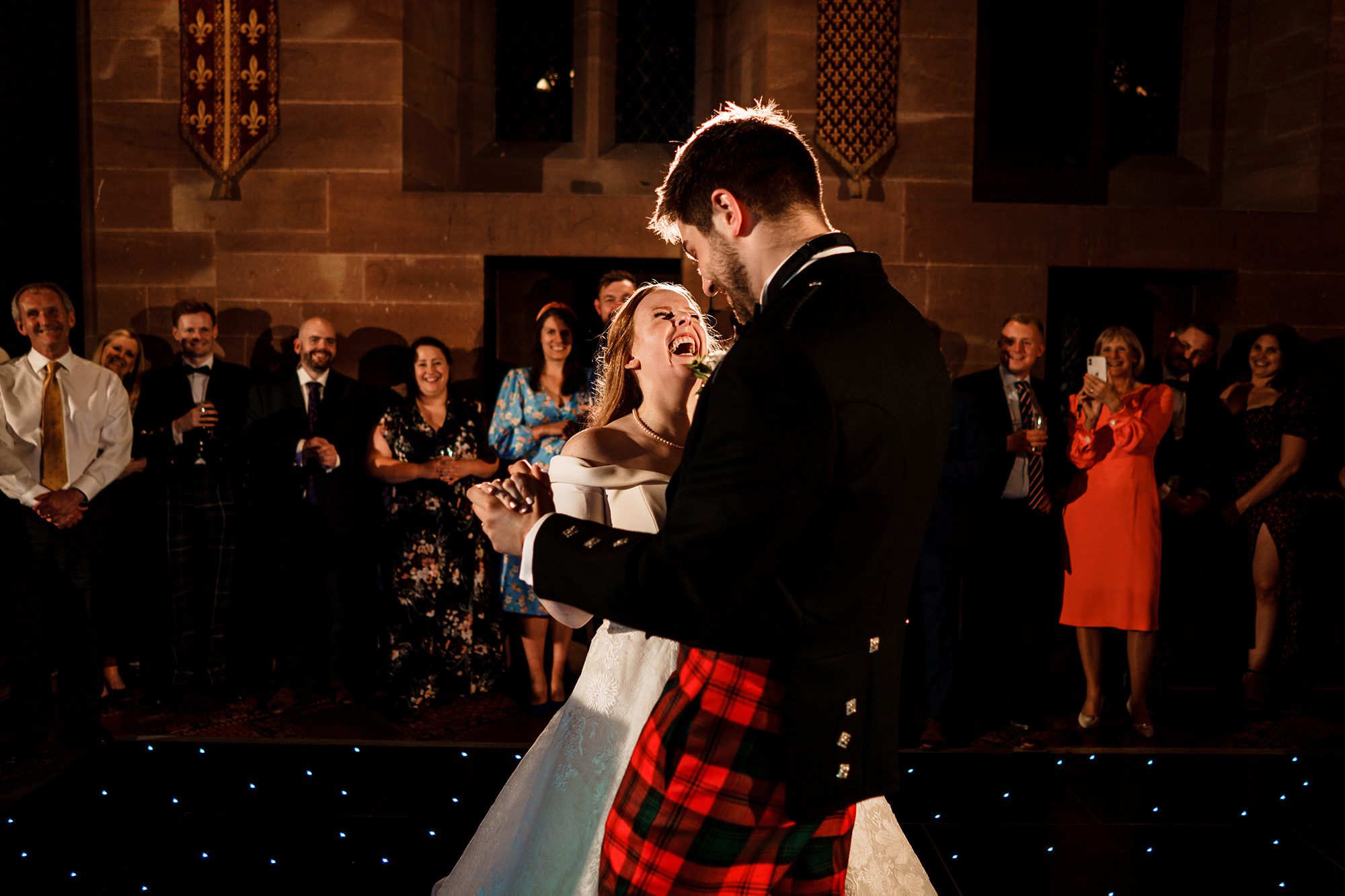 bride laughing during her first dance with her husband at Peckforton Castle