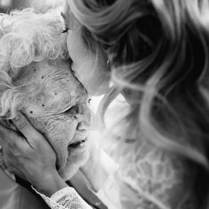 black and white moment of bride kissing her grandma