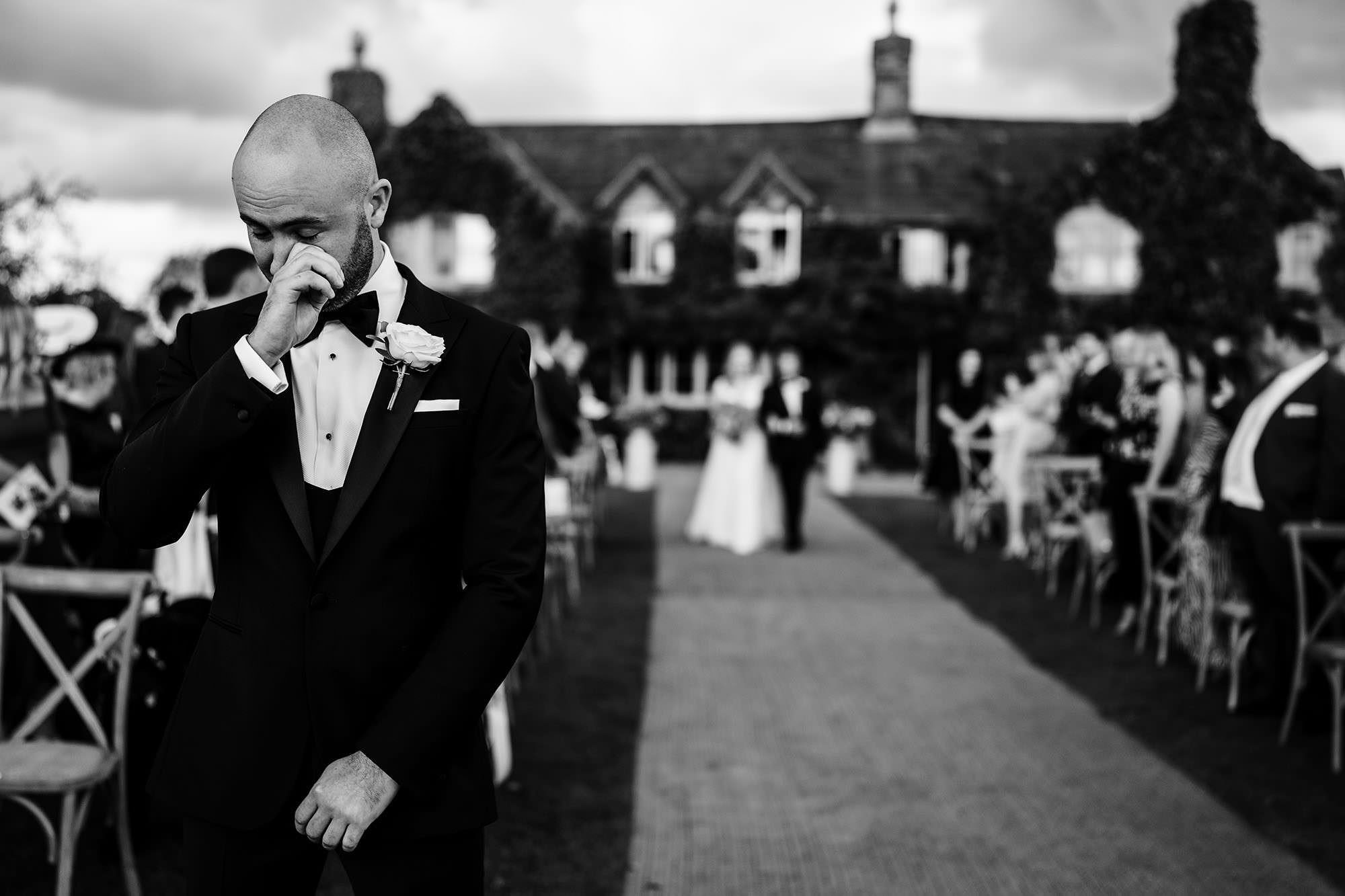 a candid wedding moment of groom waiting for his bride