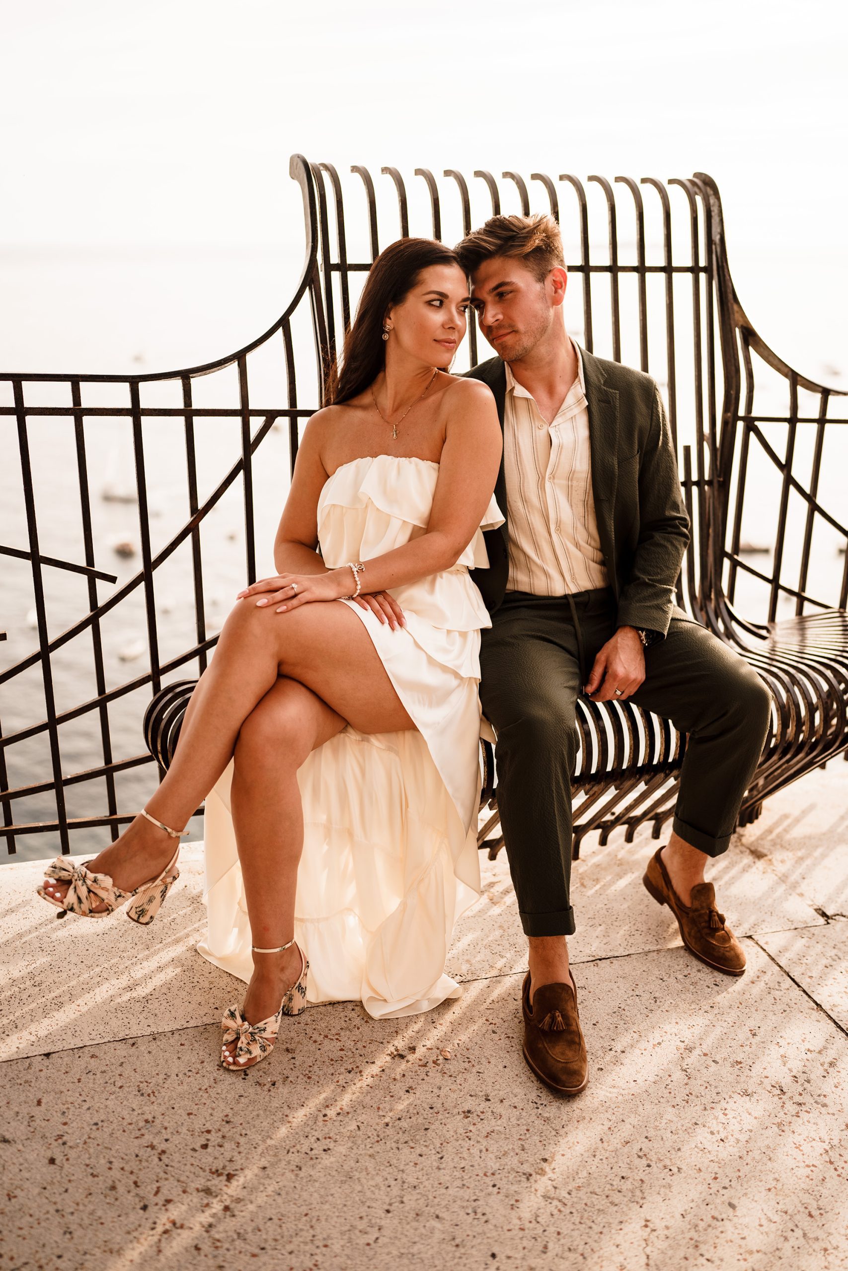 couple sit on bench by elopement photographer