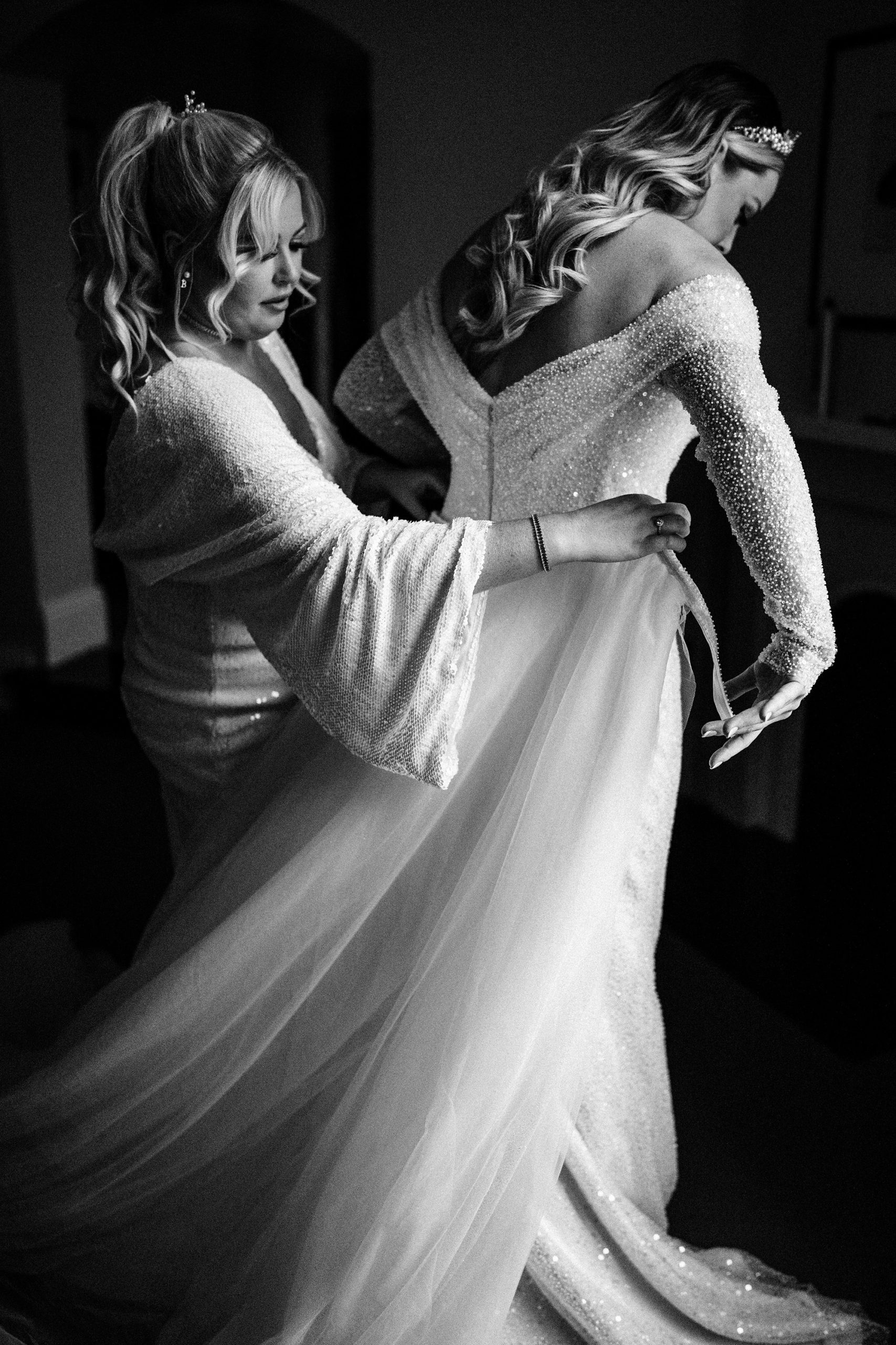 brides sister helps her into her wedding dress at the granary estates