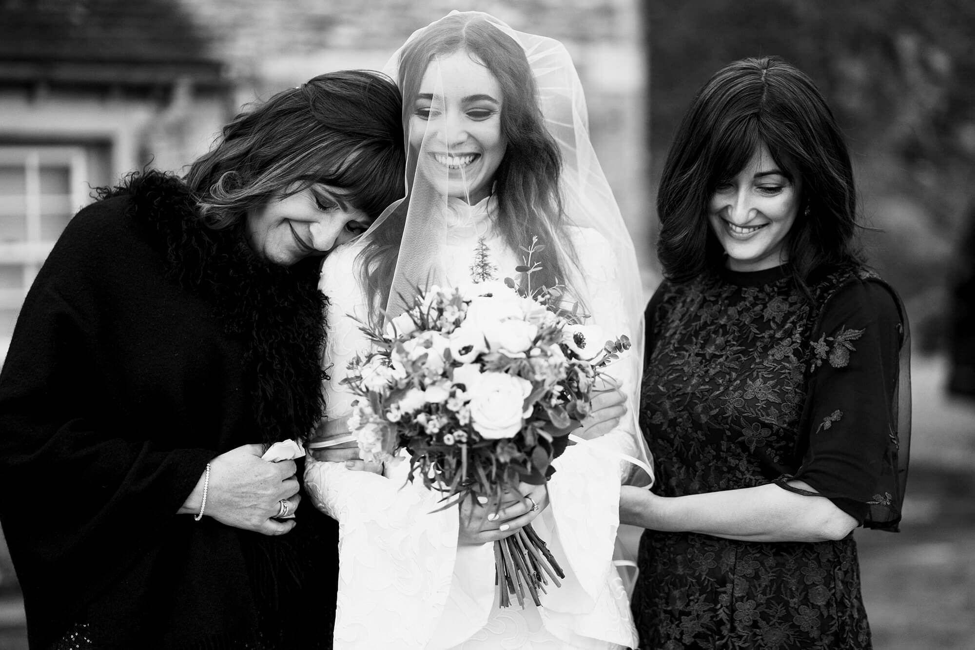 mother of the bride hugs her daughter at wedding ceremony