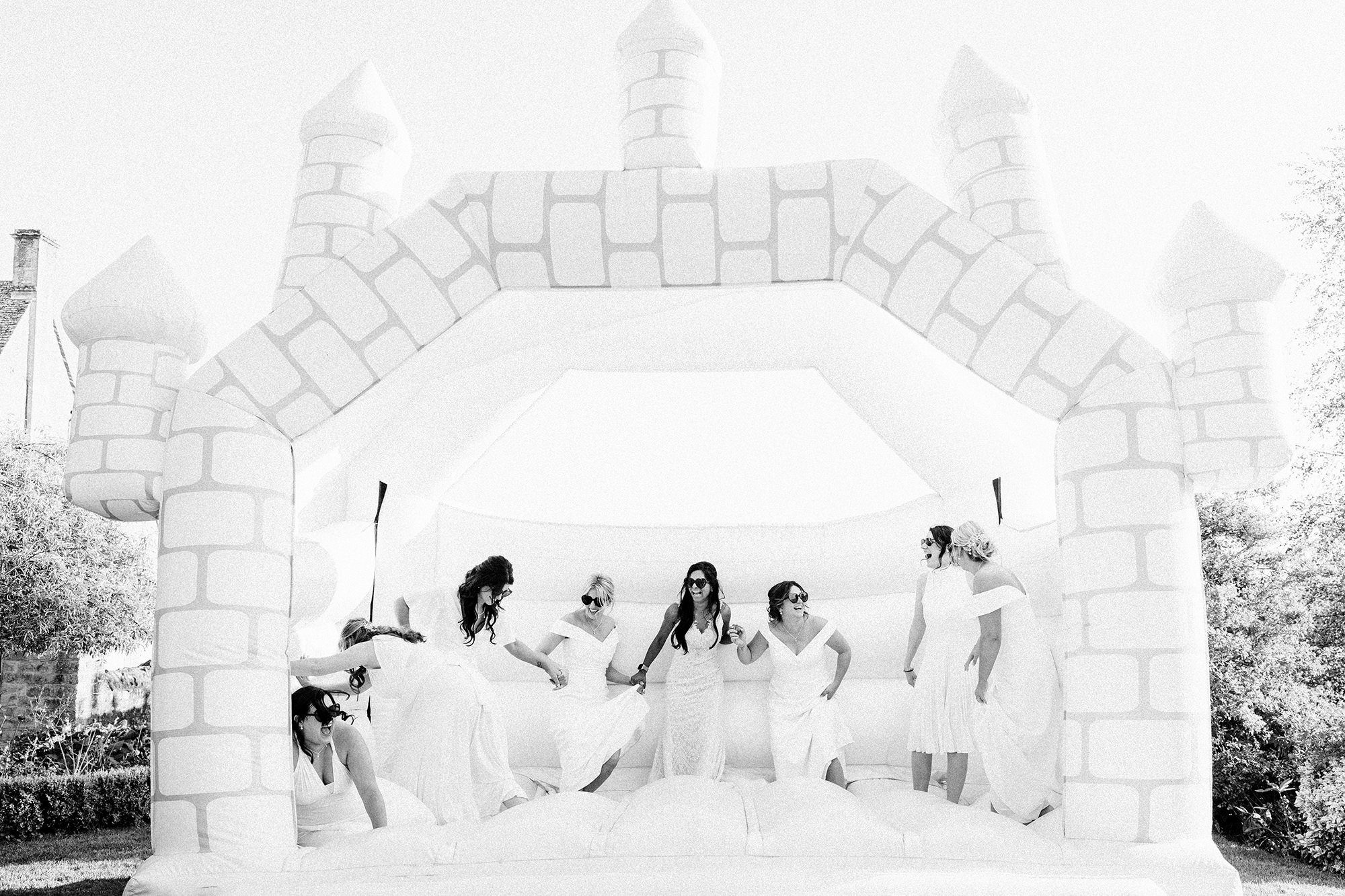 bride and bridesmaids bouncing on castle for hyde house wedding photography