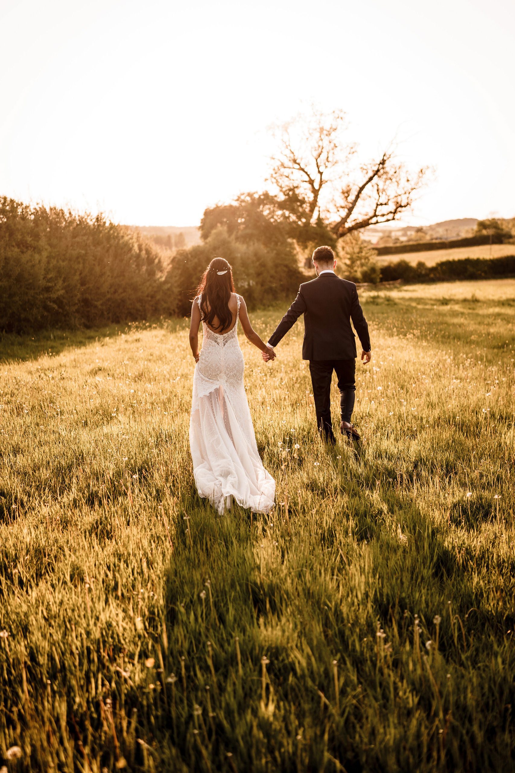 couple walking through the grass ion their wedding day for their hyde house wedding photography