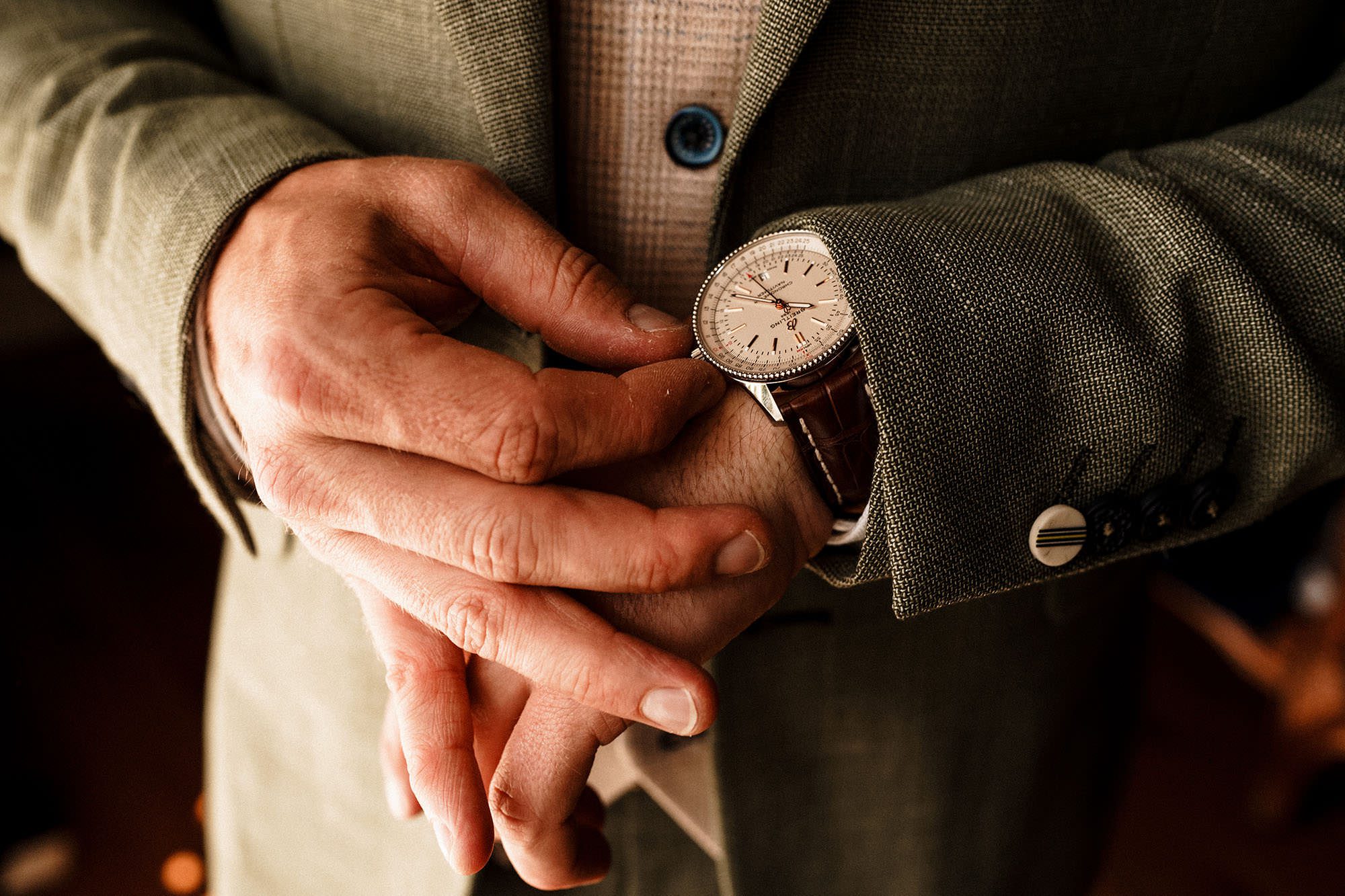 groom adjusts his wedding watch before his wedding ceremony at Woodhill hall
