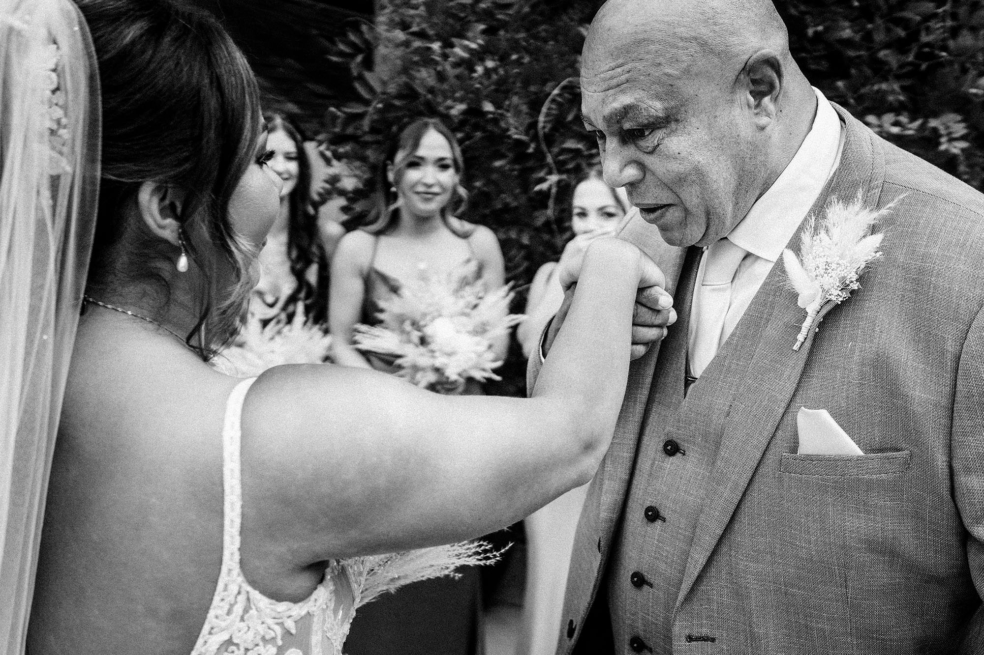father of the bride kisses his daughters hand at Woodhill hall wedding