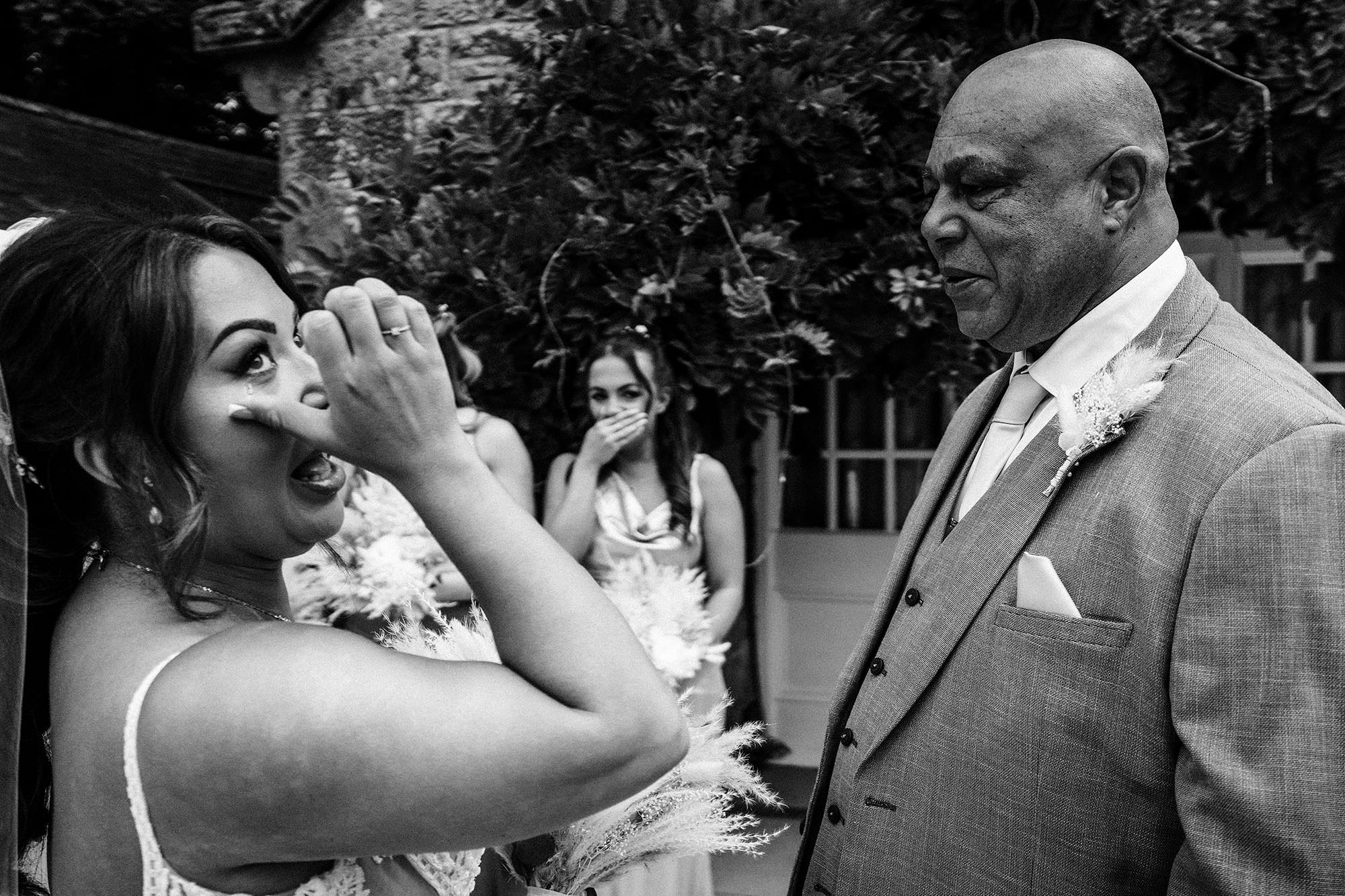 emotional bride wipes a tear from her eye on wedding day at Woodhill hall