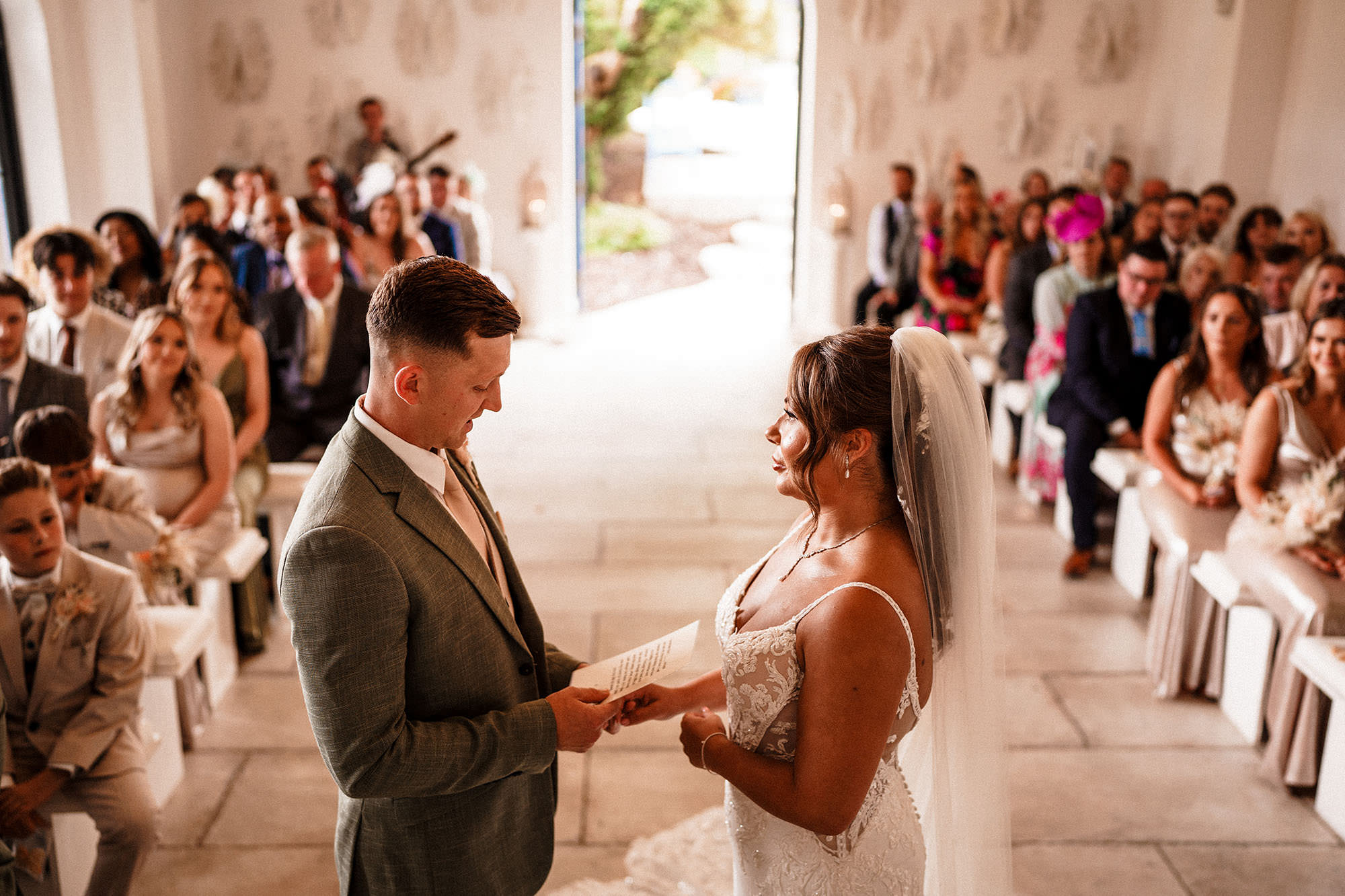 bride and groom saying vows to each other during wedding ceremony