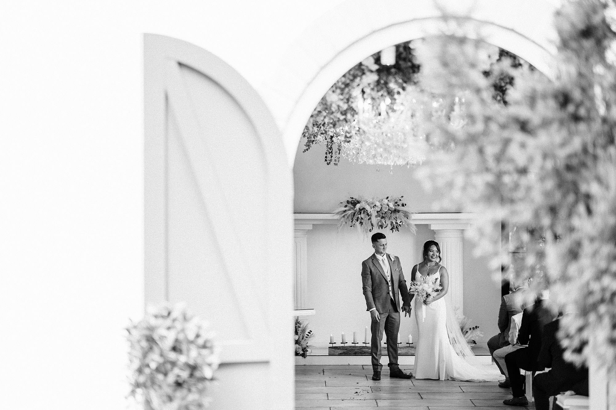 bride and groom though the doors of the olive room at woodhill hall