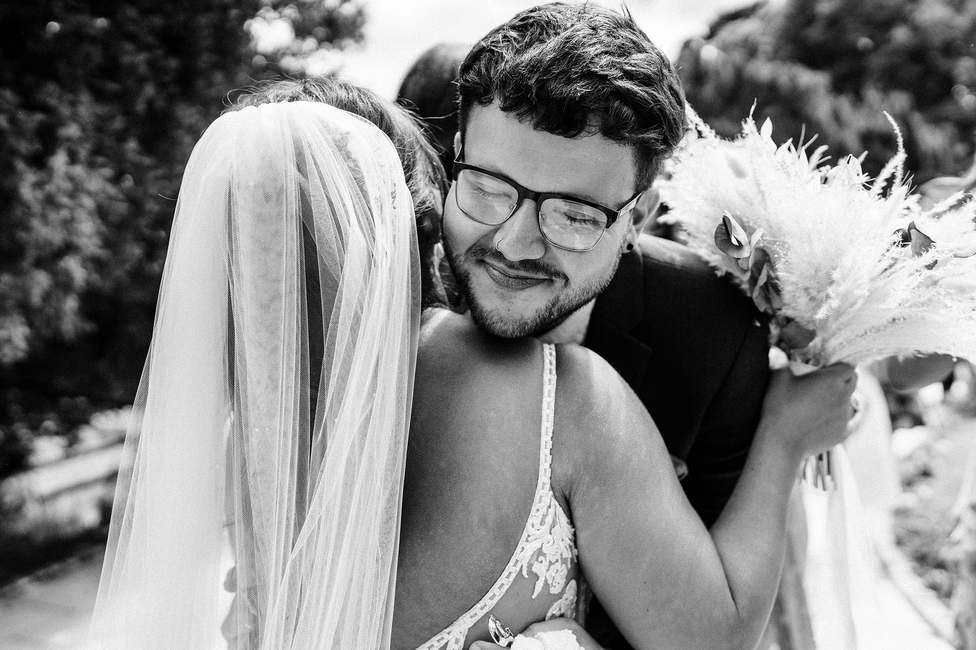 guy hugs the bride on her wedding day