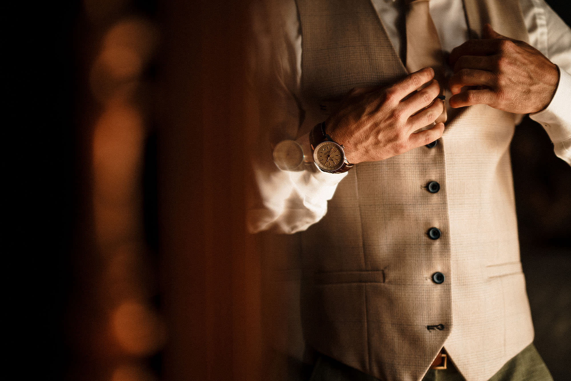 groom adjusting his wedding outfit