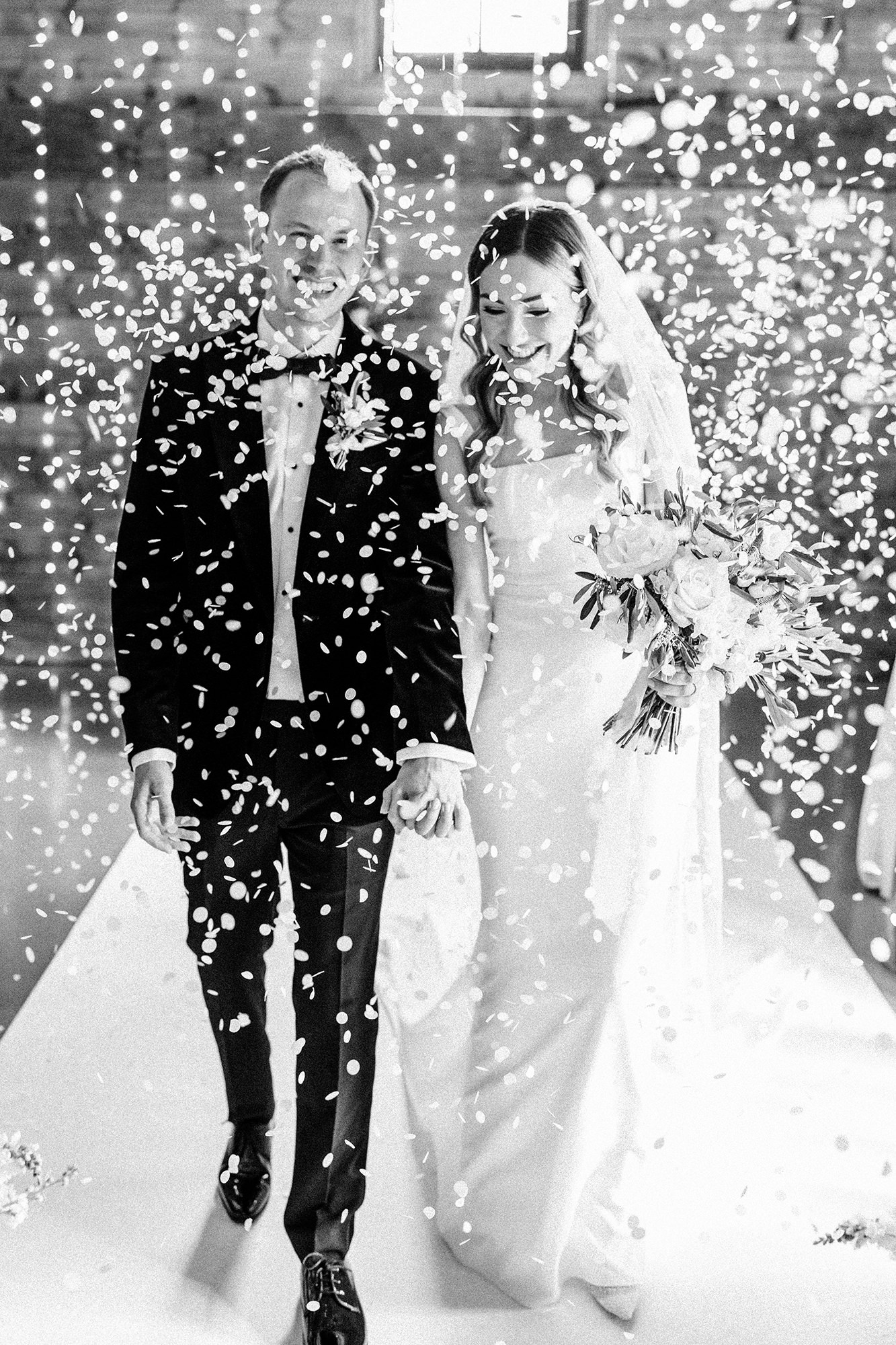 Marone and Olly walking through confetti at Scarlett Hall wedding in Cheshire