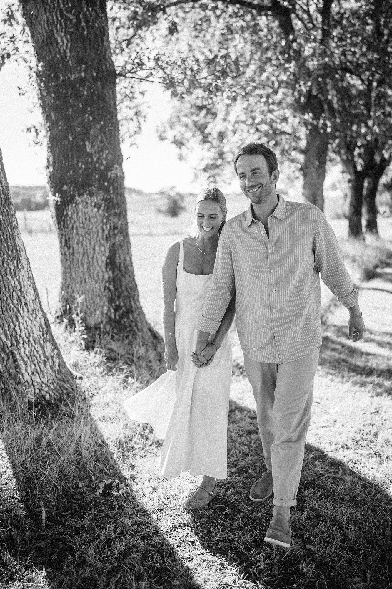 Natural black and white photograph of Anne-Sophie and Clément walking together