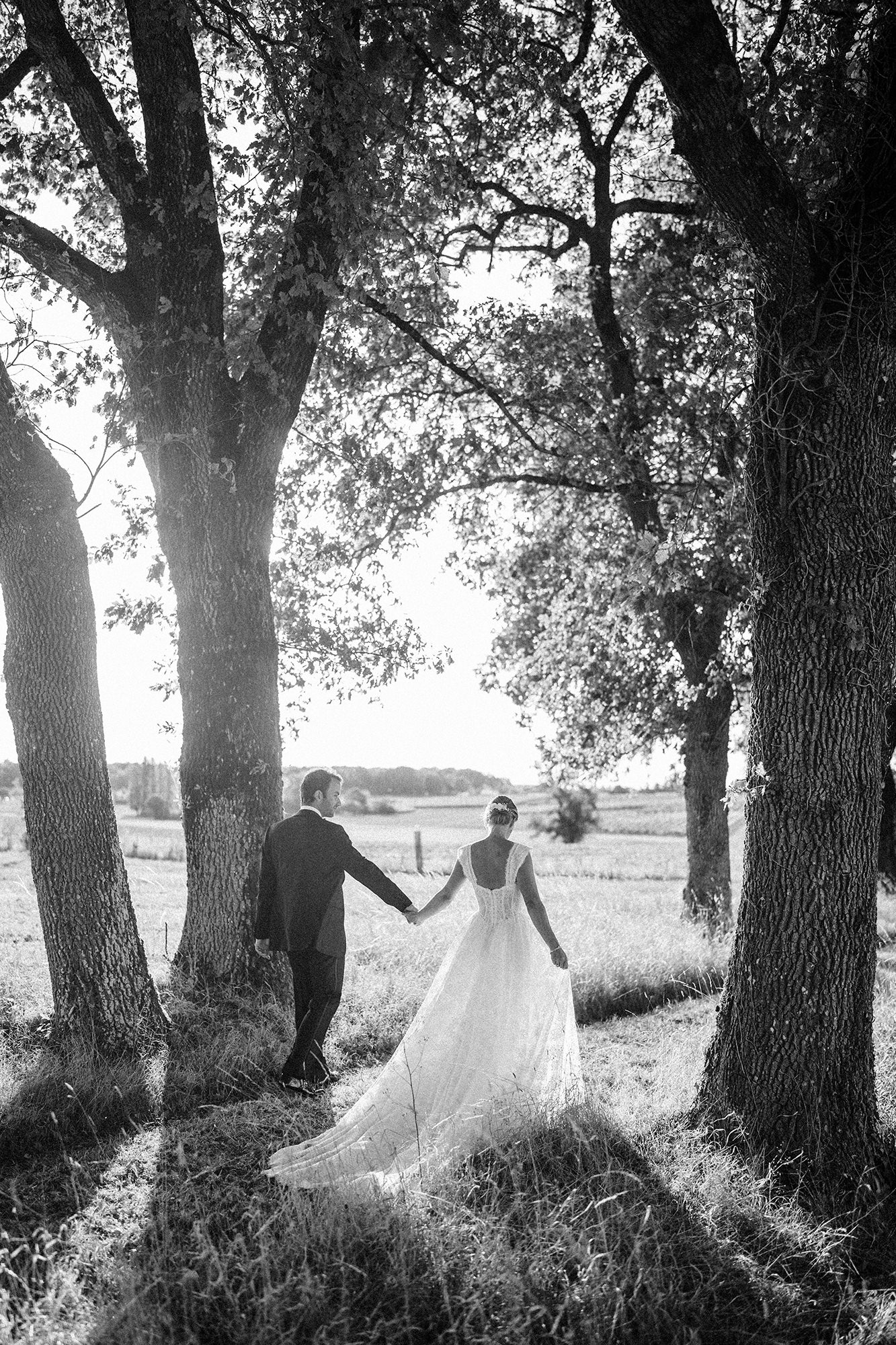 Black and white wedding portrait in the tree-lined grounds of La Cannonerie