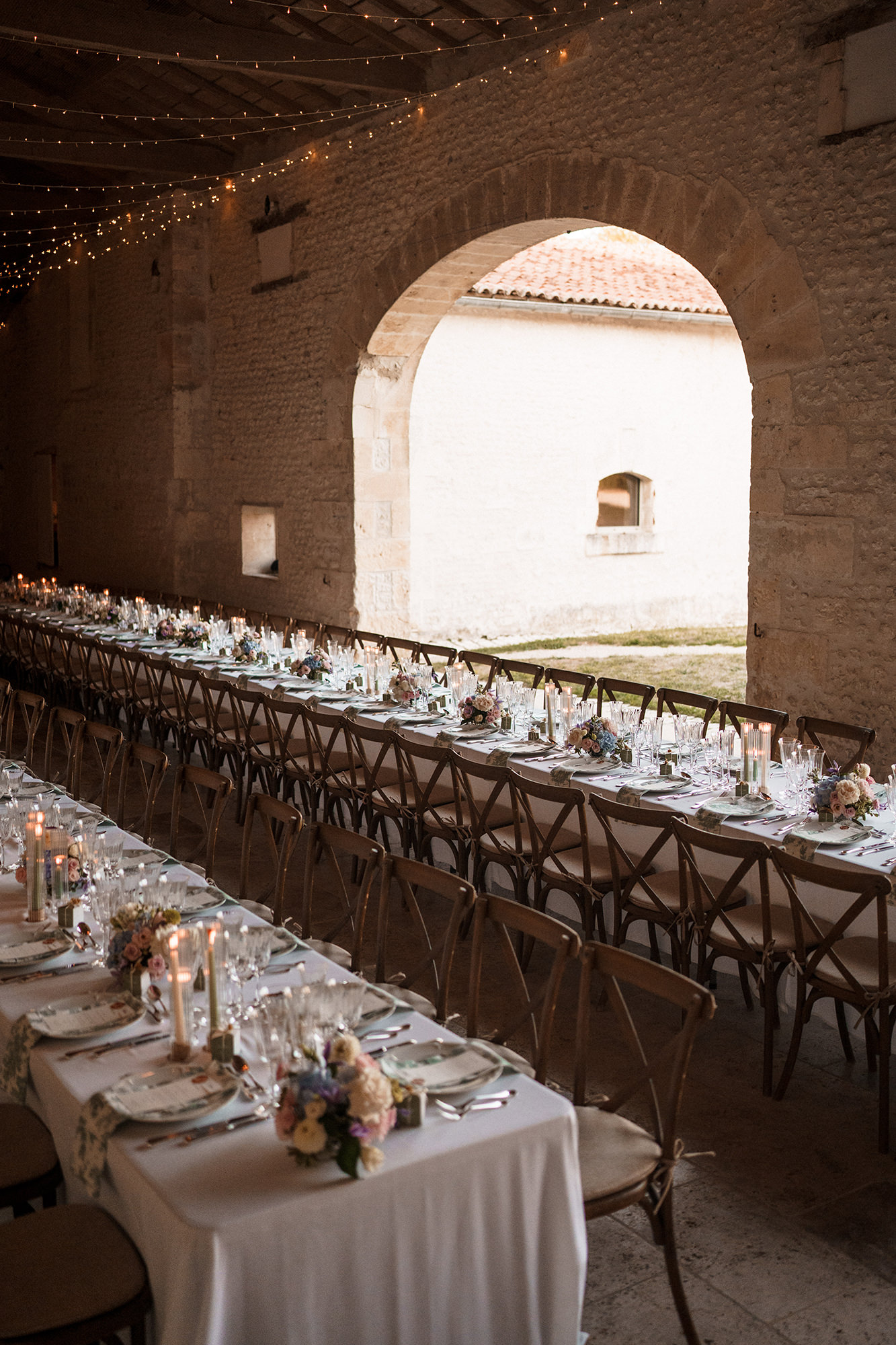 Wedding tables beneath the stone arches at La Cannonerie