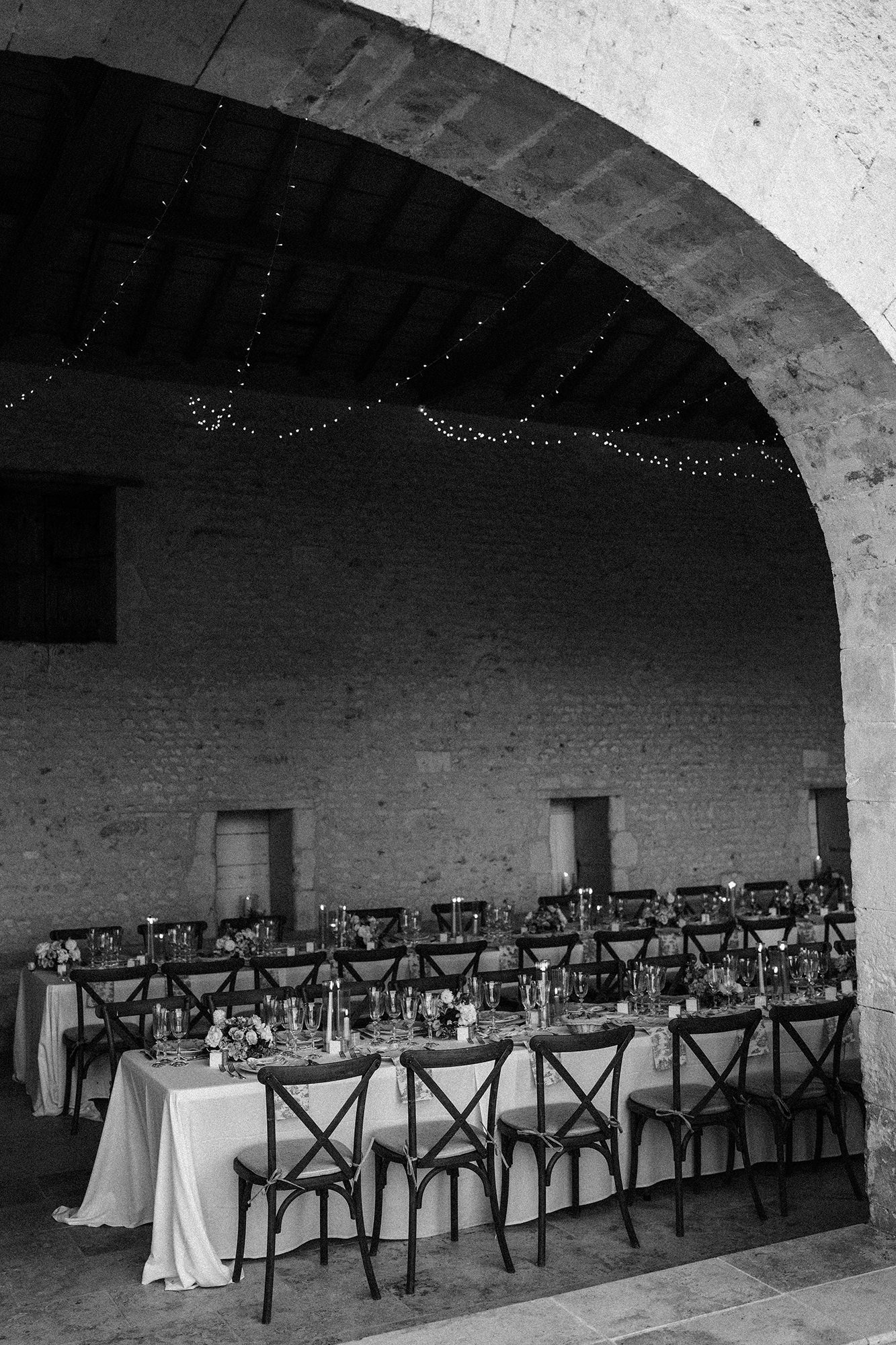 Wedding breakfast photographed through the stone arches at La Cannonerie