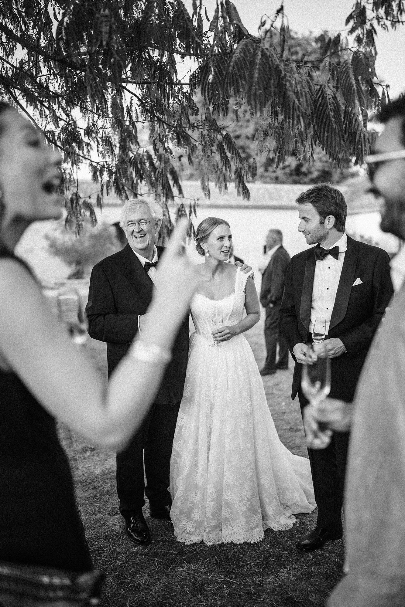 Black and white documentary wedding photograph of guests at La Cannonerie