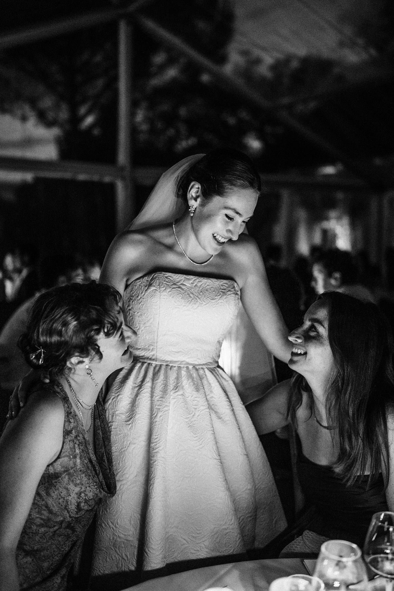 Bride laughing with wedding guests during dinner in France