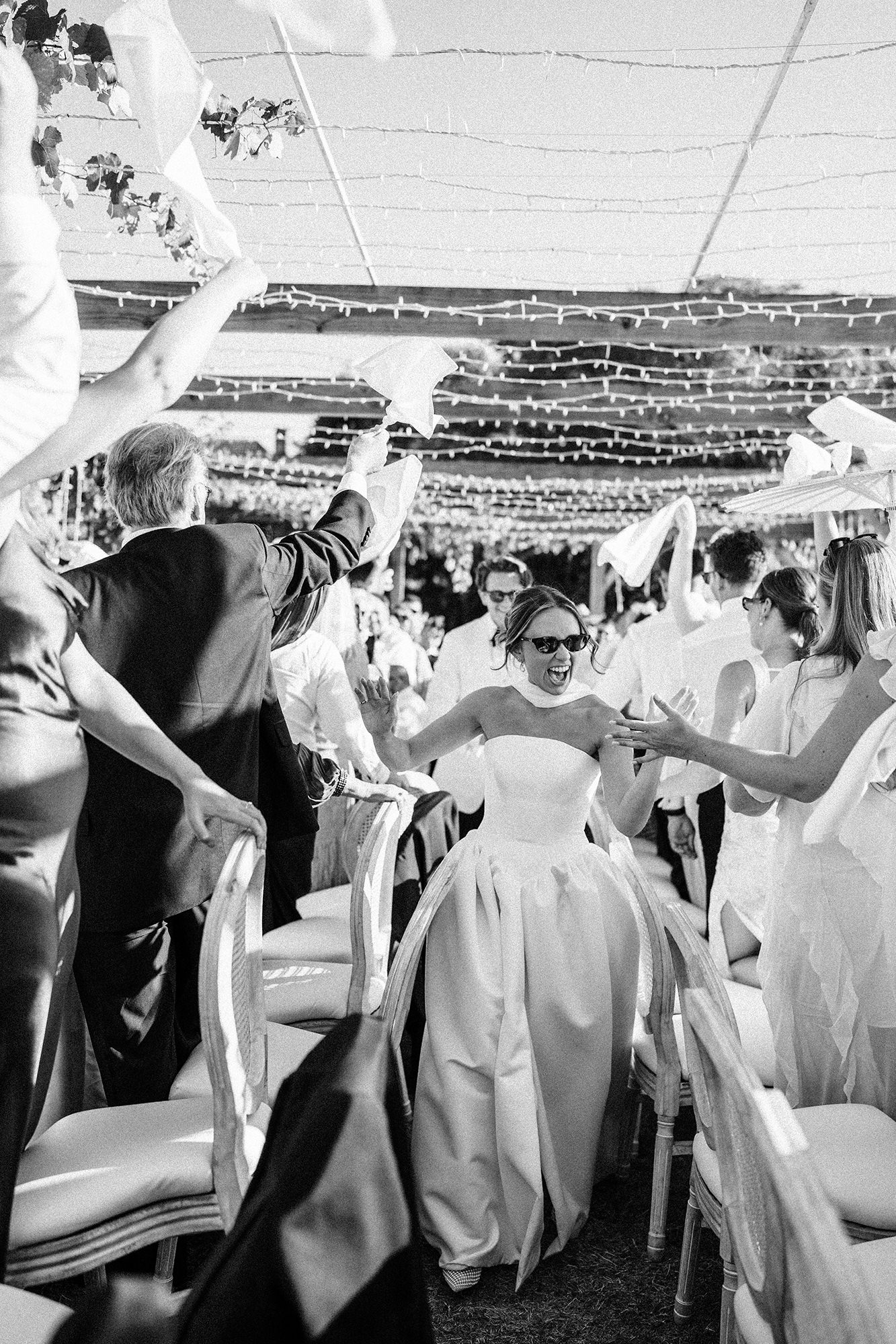 Bride celebrating amongst wedding guests at an outdoor reception in France
