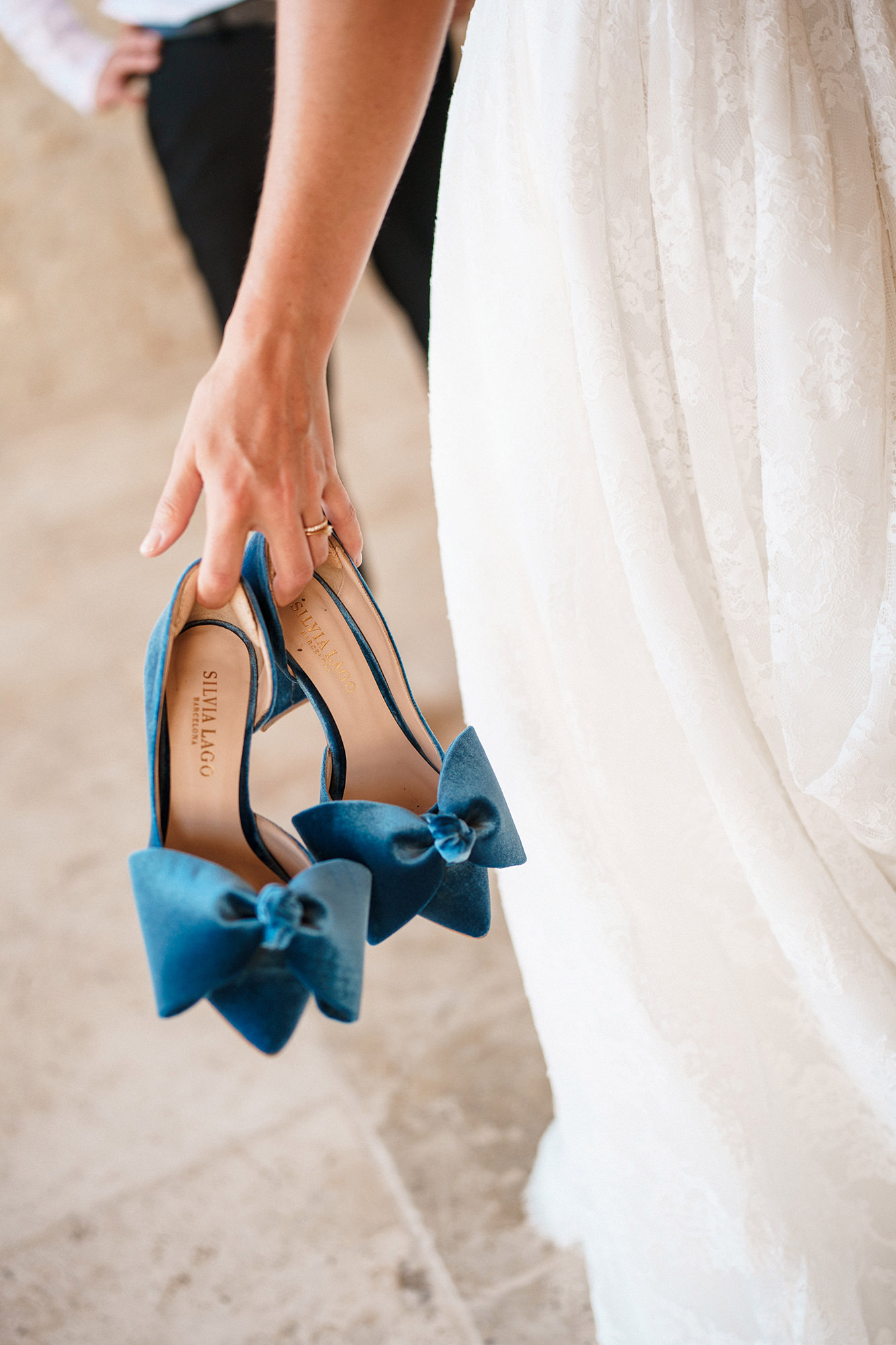 Bride carrying blue wedding shoes during preparations in France