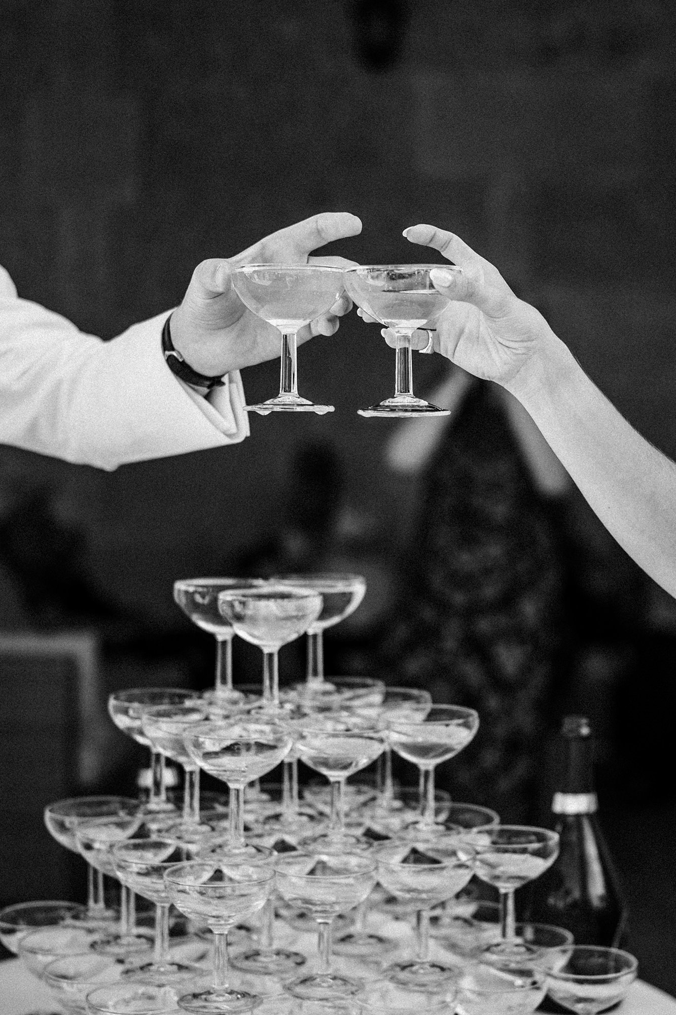 Newlyweds raising champagne glasses above a champagne tower