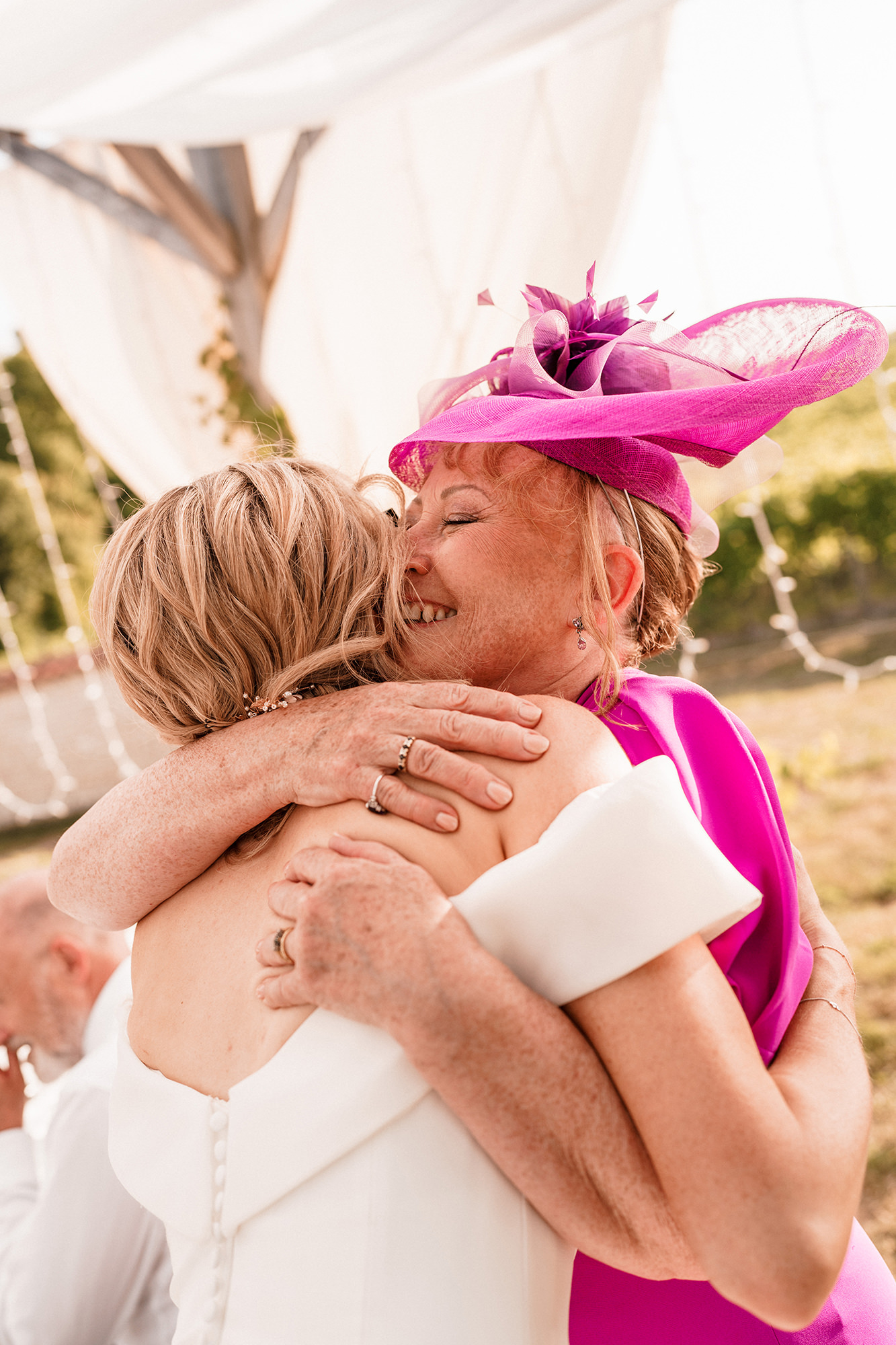 Bride sharing an emotional hug with a wedding guest in France