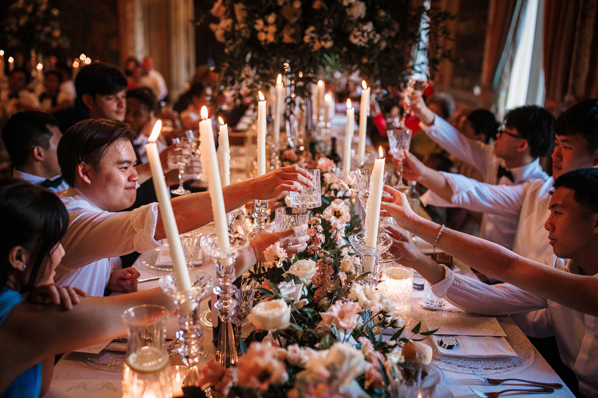 Wedding guests raising glasses during a candlelit dinner in France
