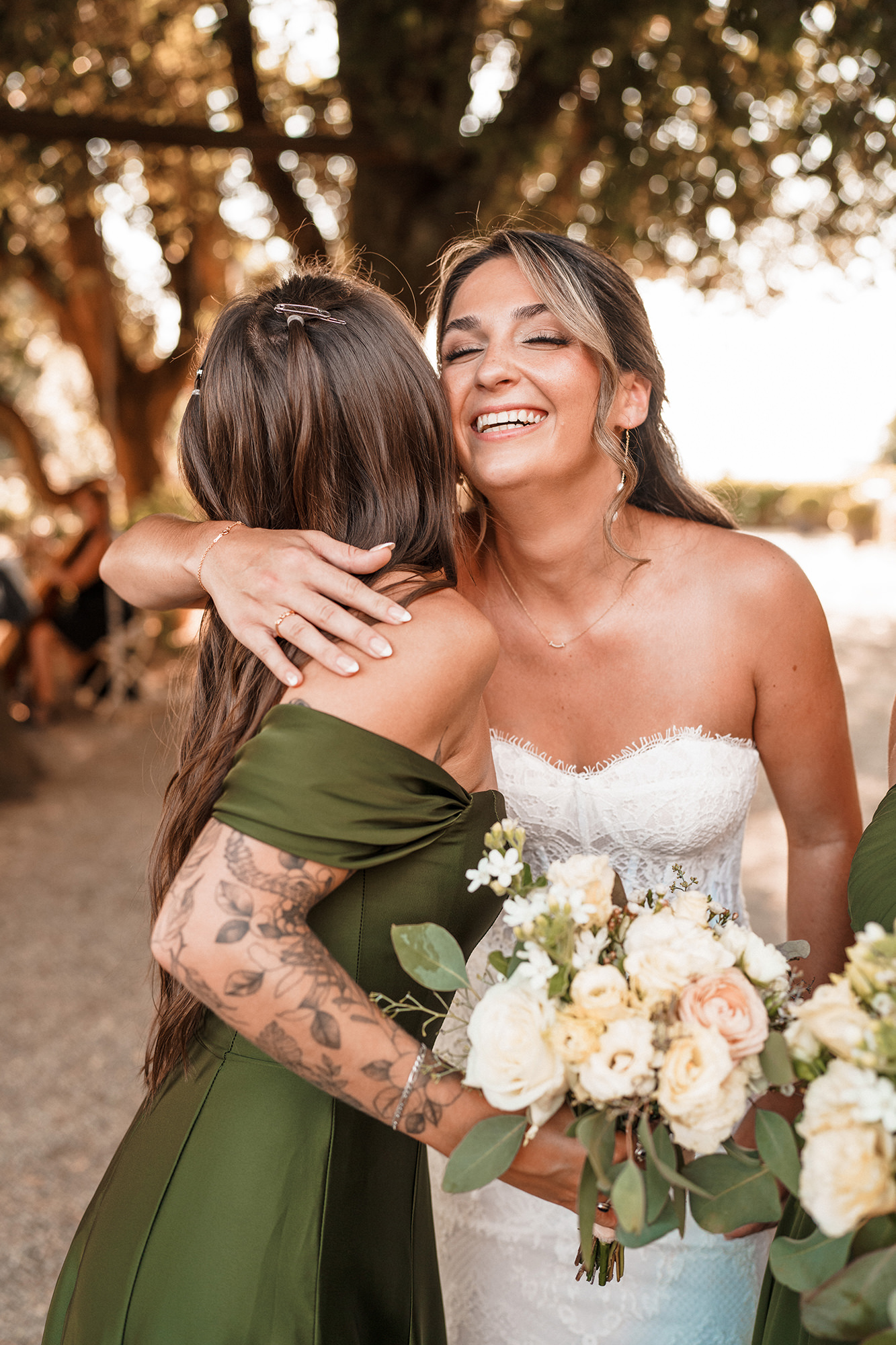 Bride laughing while hugging a bridesmaid at a wedding in France
