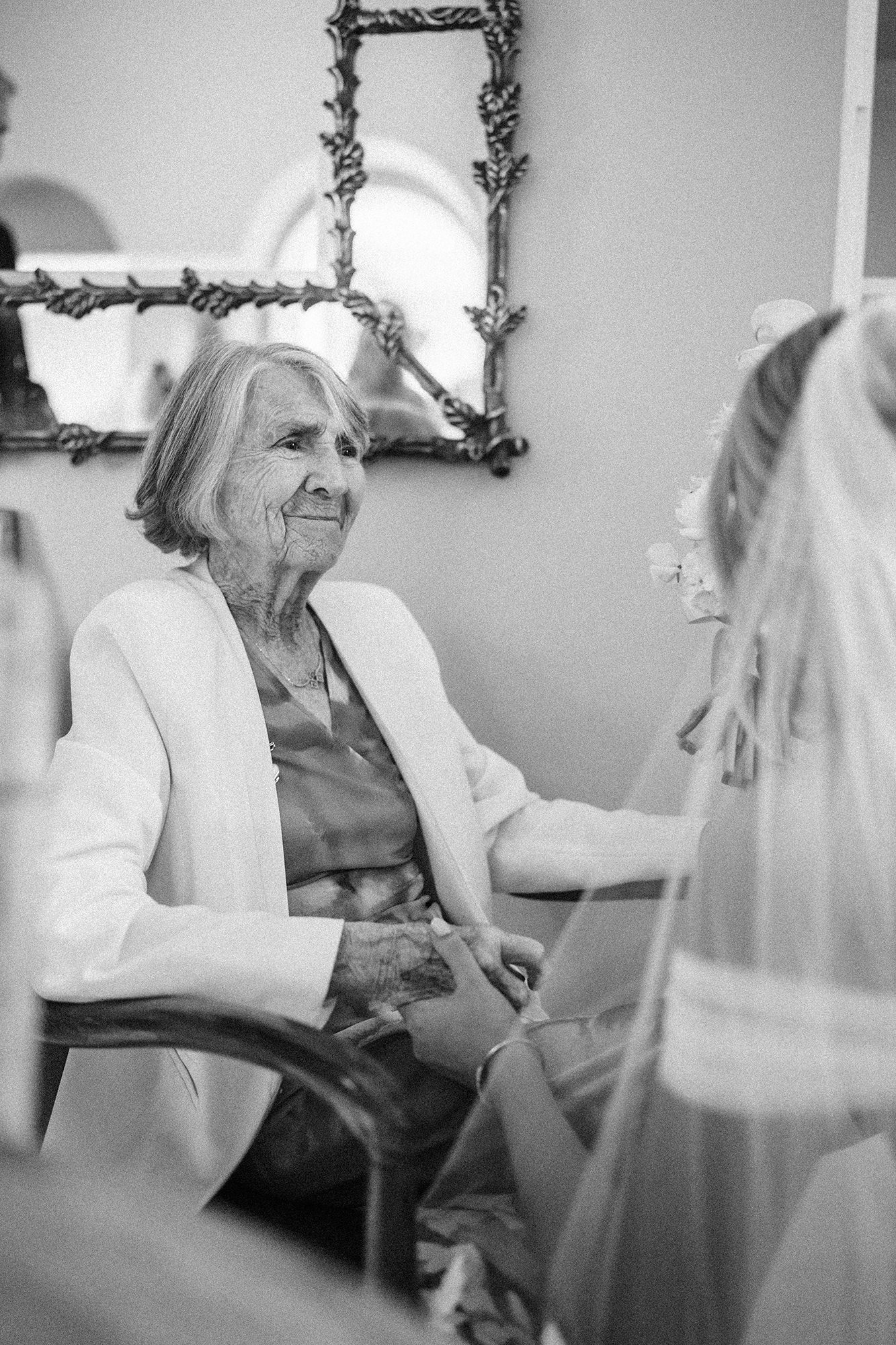 Grandmother sharing a quiet moment with the bride before a wedding in France