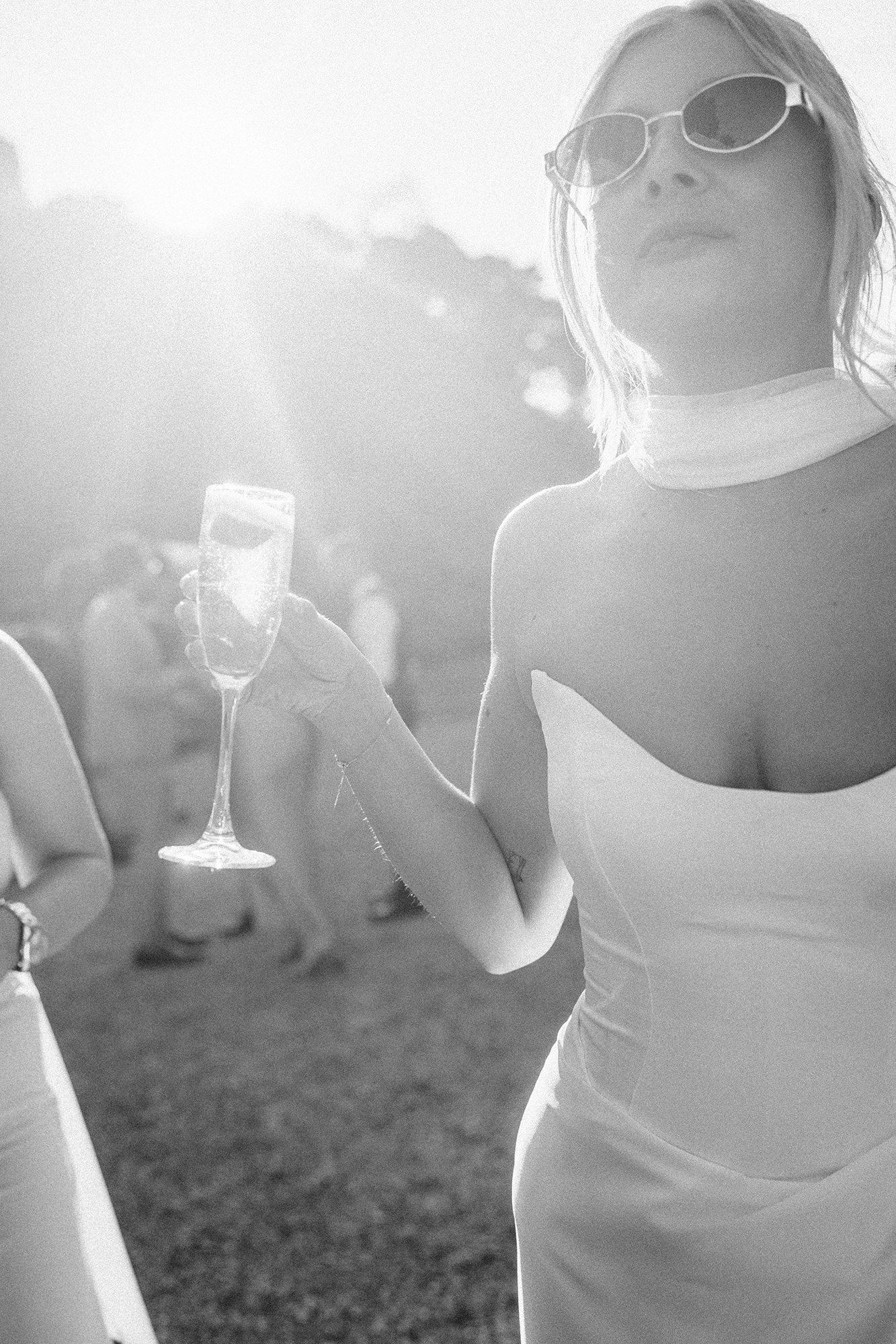 Bride enjoying champagne in bright French evening light