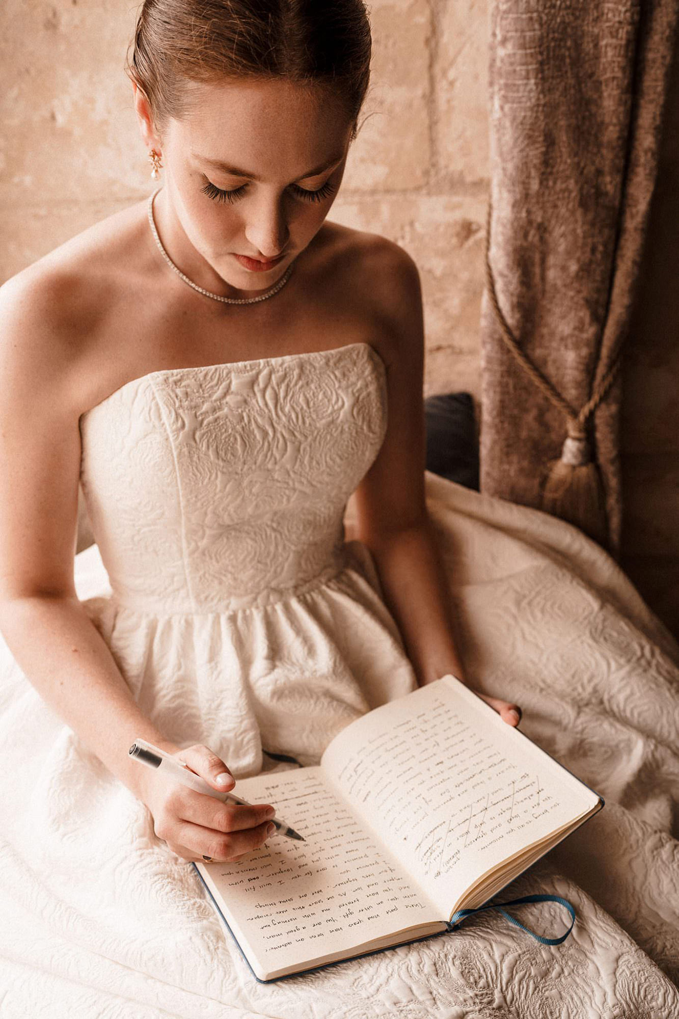 Bride writing in a notebook before her wedding ceremony in France